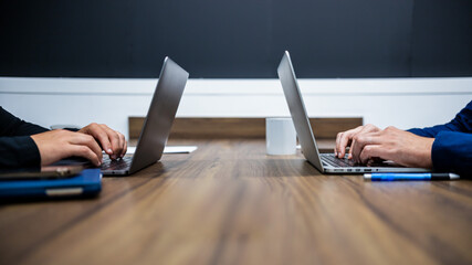 Dos personas trabajando en la oficina. Manos tecleando en diferentes laptops. Concepto de...