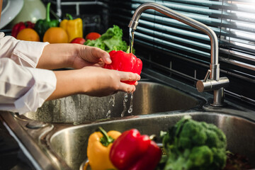 Hand of maid washing tomato fresh vegetables preparation healthy food in kitchen