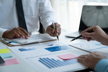 Team of business people, investors calculating on financial data Business Growth Analysis by pointing to statistics movement of data from graphs Chart to prepare planning in the meeting room.