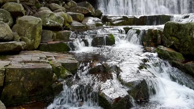Mountain waterfalls with the rocks in the forest, wide shot, panning, slow motion, hd. ProRes 422 HQ.