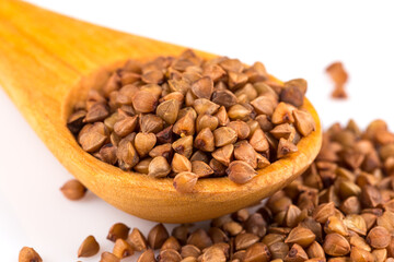 Uncooked buckwheat on wooden spoon