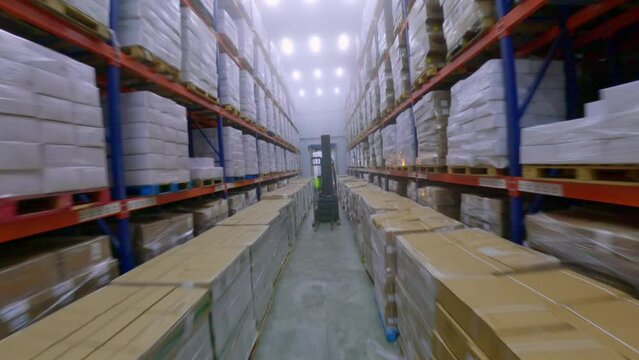 FPV drone flight between shelves of cold storage, distribution warehouse