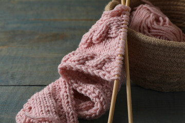 Fototapeta na wymiar Soft pink woolen yarn, knitting and needles on wooden table, closeup. Space for text