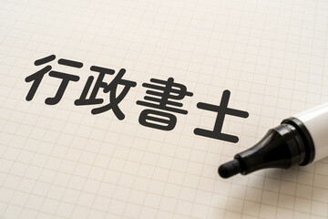 行政書士と書かれたノートとマーカー