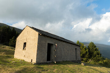 Fototapeta na wymiar Summer landscape with mountain hut and cloudy sky