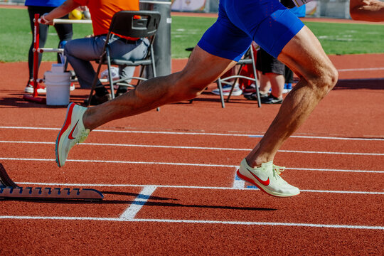 legs male athlete start running in starting blocks sprint race, Nike spikes shoes