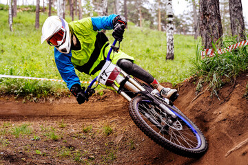 male racer athlete riding cornering turn downhill race, sports summer games in mountain bike
