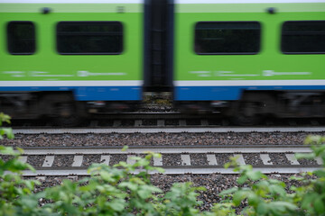 High speed train blurred side view. White green train fast moving side view. blurred train in motion.