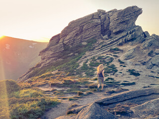 Girl runs in rocky mountains at sunset. Mount Vuhaty Kamin. Chornohora, Ukraine.