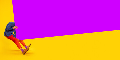 Ambitions and motivation. Man in colorful, stylish clothes over yellow background with purple...