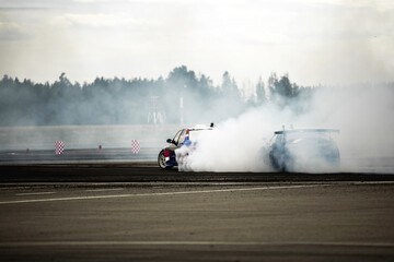 Abstract blurred two drift cars battle with smoke from burned tire