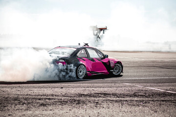 pink car drifting, Blurred image diffusion race drift car with lots of smoke from burning tires on...