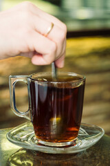 Pouring hot black Arabian tea into cup
