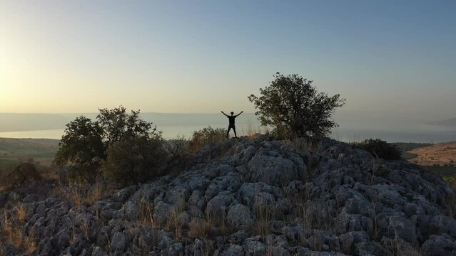 sunrise over the golan heights and lake of galilee in israel. drone flying over a hill in the galilee towards the sunrise. morning views of the sea of galilee from the air. israeli sunrise.
