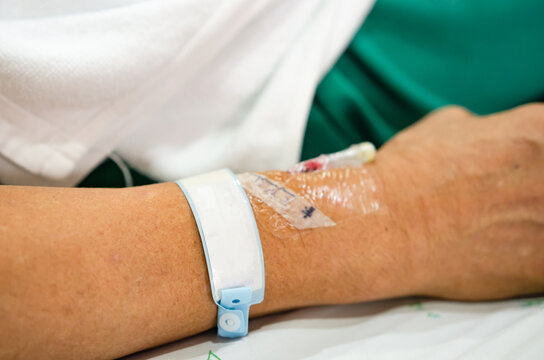 selective focus of patient wrist band tag who lay in white patient bed