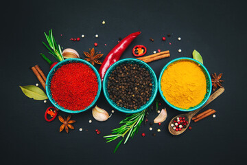 Spices and seasonings for cooking on a dark background.