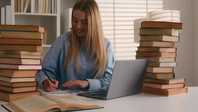 Caucasian student happy smiling girl woman studying with laptop and books homework learning online knowledge prepare for test exam study at library cram SAT test bookworm research history prep course