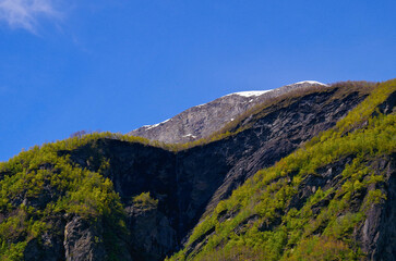 Fototapeta premium Waterfalls and mountain ranges along the most beautiful train journey Flamsbana between Flam and Myrdal in Aurland in Western Norway 