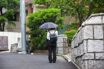 日傘を持って街で散歩している女性観光者の姿