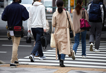 朝の通勤時間帯で横断歩道を渡る人々の姿