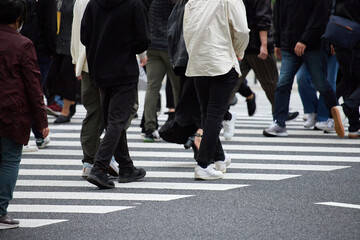 朝の通勤時間帯で横断歩道を渡る人々の姿