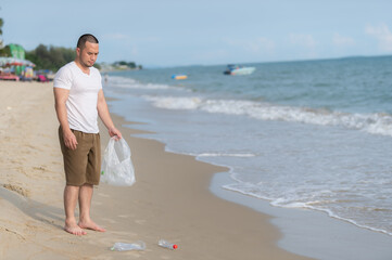 Asian man keep garbage at inside sea beach,people volunteer keeping garbage plastic bottle