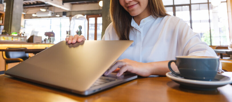 Closeup of a woman opening or closing laptop computer, getting ready for work, finished work in office
