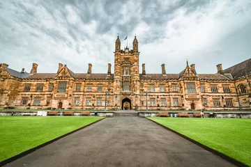 Tuinposter The facade of the historical University of Sydney Quadrangle in cloudy days © Gavin