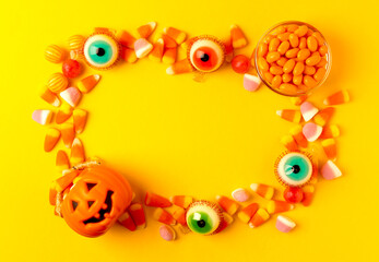 Halloween candy corn on texture background.Classic white, orange and yellow candy corn sweets for Halloween with.copy space.Halloween holiday concept with candy corn and jack o lantern.copy space