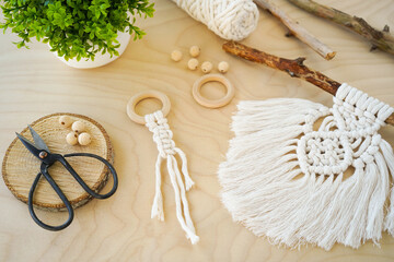 Fototapeta na wymiar A Hand-Made Macrame amulet with Wooden Rings in a Beautiful Background Setting the Mood for Creativity.