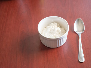White ceramic bowl of cottage cheese with spoon