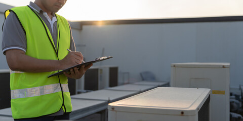 Asian maintenance engineer works on the roof of factory. contractor inspect compressor system and plans installation of air condition systems in construction. Checklist, inspector, control