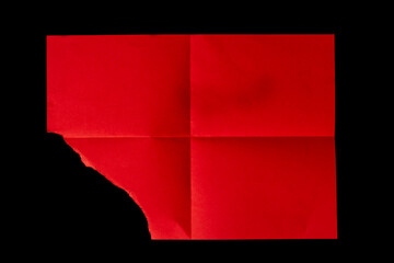 Torn red sheet of paper on a black background.