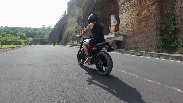 The concept of extreme recreation, a motorcycle biker riding on a mountain road, freedom and enjoyment of life
