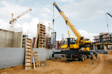 Building and construction scene. Heavy machinery lifting up materials. Blue sky, real estate development