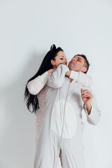 a man and a woman in pajamas in the morning on a white background in the room