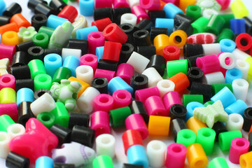 Bright colorful background of small plastic scattered beads for handicraft