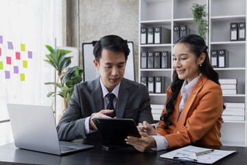 Two employees working at table in a modern office, Asian man and a woman work at office desk, Business campaign result and project planning concept, financial planning,  