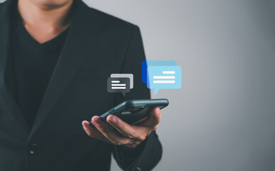 Businessman using smartphone to type, live chat and conversation, social networking concept, doing business, working from home. In the chat box icon appears remind social media marketing technology 