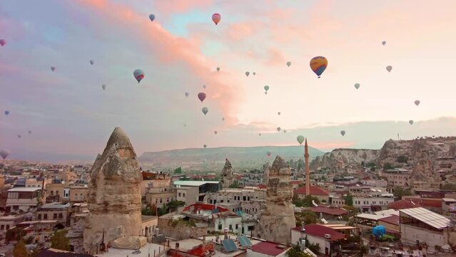 Panoramic view of Goreme, Turkey with hot-air balloons at sunrise. Goreme is known for its fairy chimneys, eroded rock formations