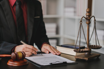 concept of justice and law A male judge in the courtroom on a wooden table and a male counselor or lawyer working in the office. Law, advice and justice concepts..