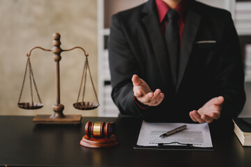 concept of justice and law A male judge in the courtroom on a wooden table and a male counselor or lawyer working in the office. Law, advice and justice concepts..