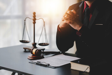 concept of justice and law A male judge in the courtroom on a wooden table and a male counselor or lawyer working in the office. Law, advice and justice concepts..