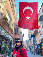 bandiera dell Turchia sventola nell vie di Instambul con un ragazza in primo piano che passeggia...