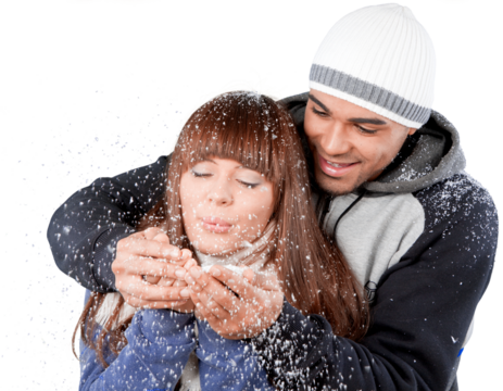 Happy young couple holding snowflakes and blowing isolated on white