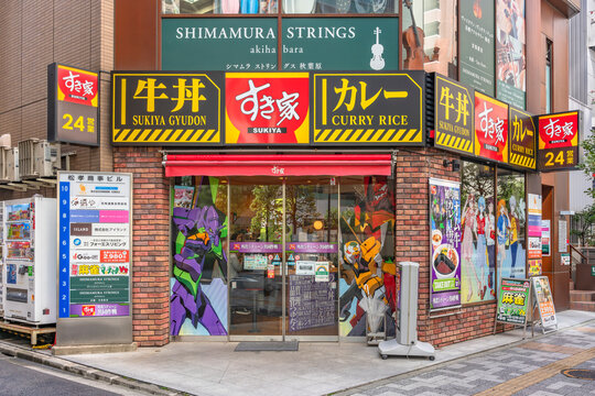 tokyo, akihabara - mar 29 2021: Fast food Sukiya restaurant which windows are decorated by wrapping stickers featuring characters and robots of famed Japanese manga and anime Neon Genesis Evangelion.