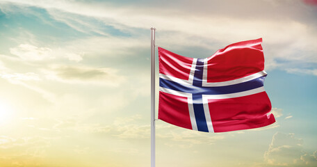 Norway national flag waving in beautiful sky. The symbol of the state on wavy silk fabric.