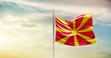 North Macedonia national flag waving in beautiful sky. The symbol of the state on wavy silk fabric.