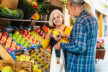 Senior man buying fresh fruits at the market - Shopping food concept