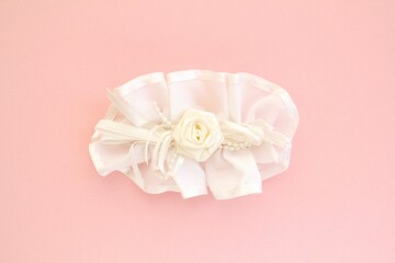 Handmade white wedding hair bow barrette on pink background. Elegant fashion design accessory for woman. Evening hairstyle silk ribbon. Hairpin for girl. Bridal clasp clips with jewellery details